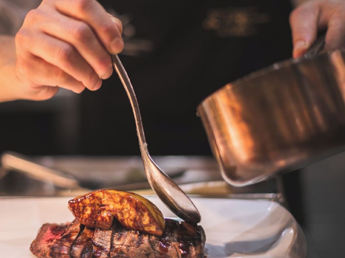 a person cutting food on a plate