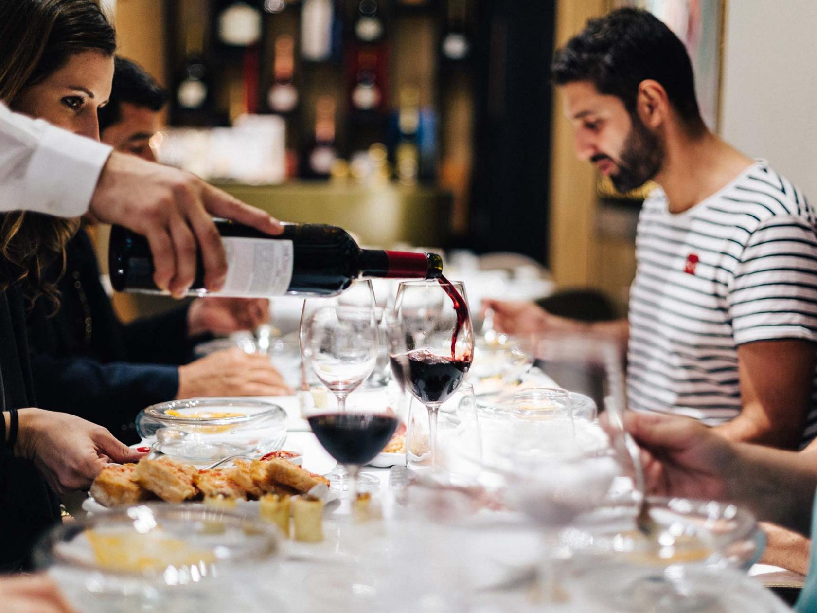 a group of people sitting at a table with wine glasses
