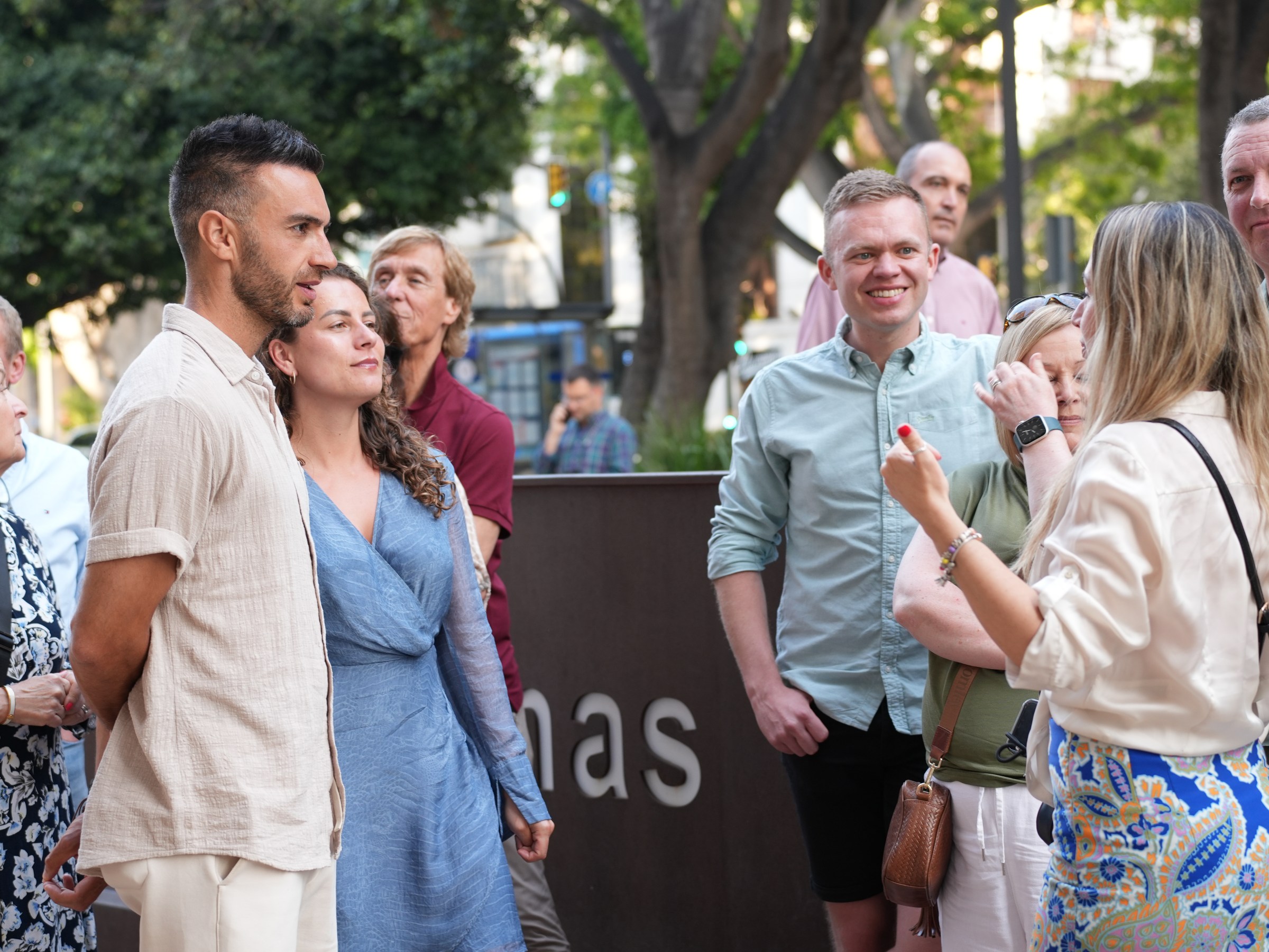 Group of people standing and talking outdoors on a city street.