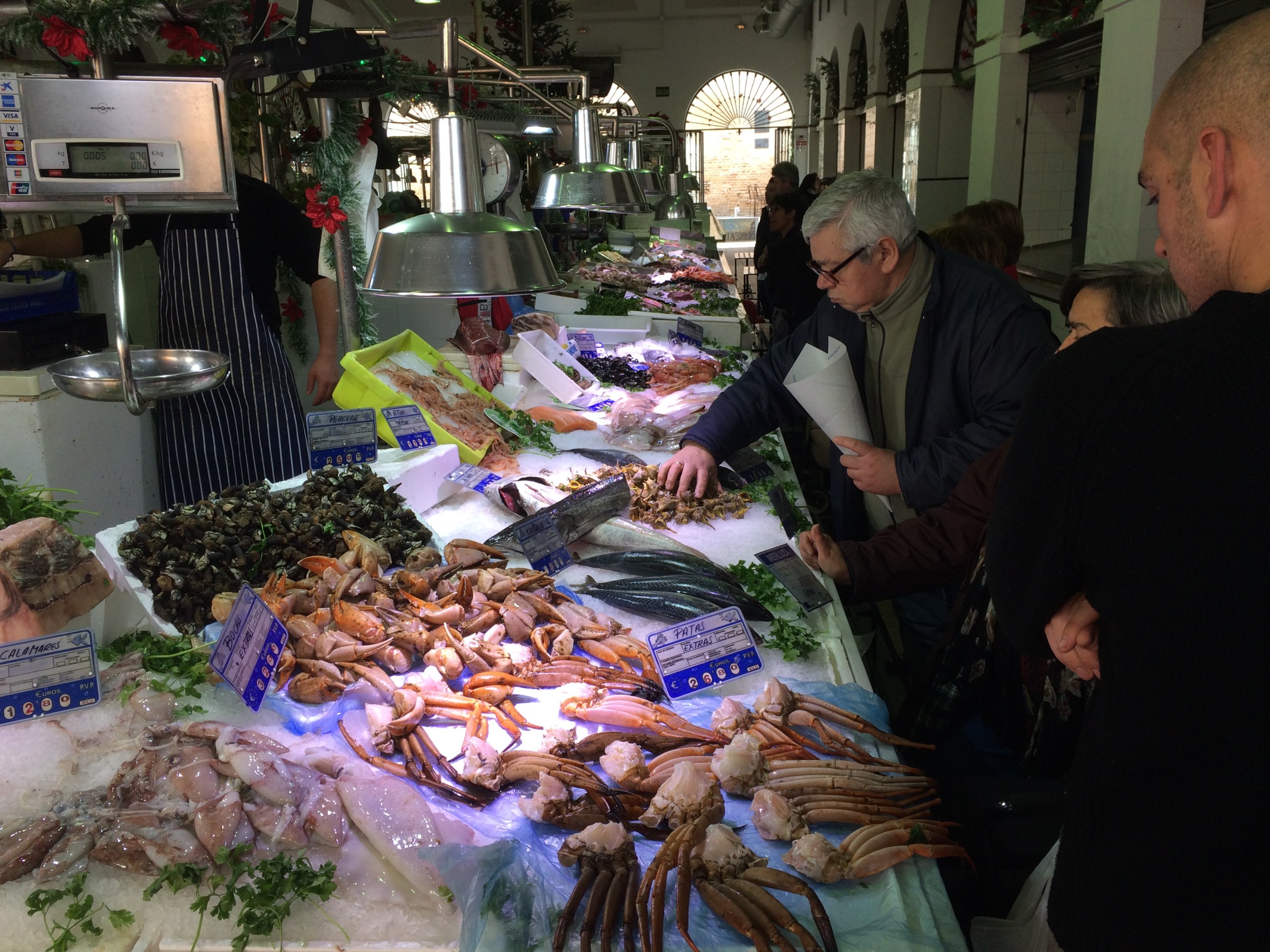 a group of people standing around a table with food