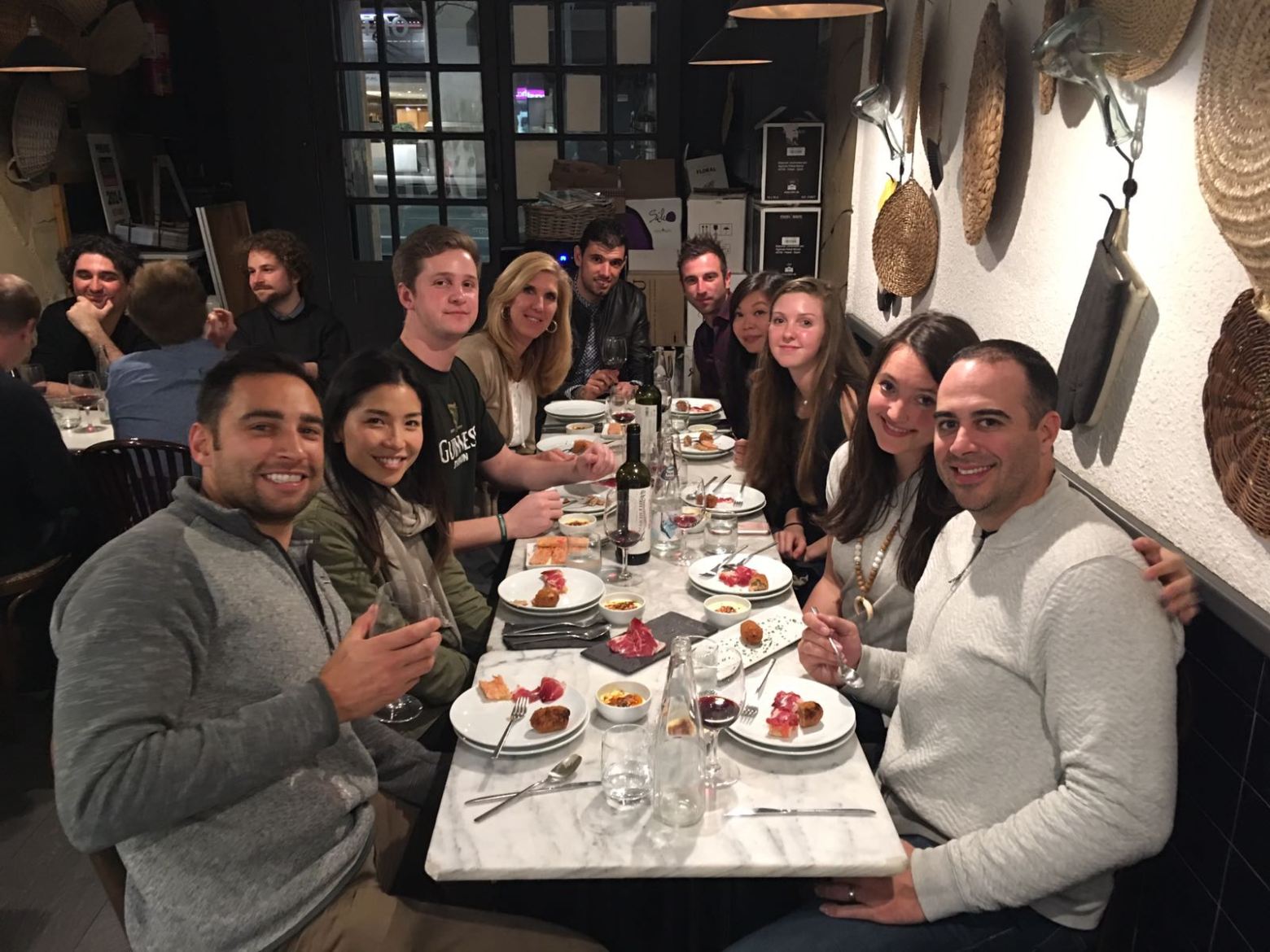 a group of people sitting at a dinner table posing for the camera