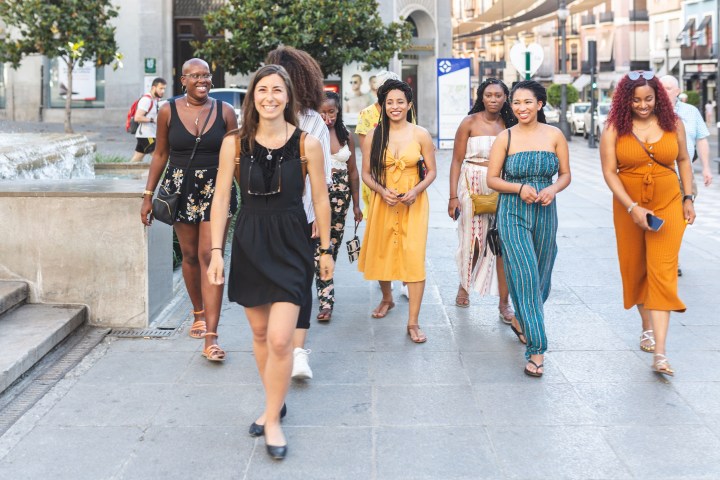 a group of people walking on a sidewalk