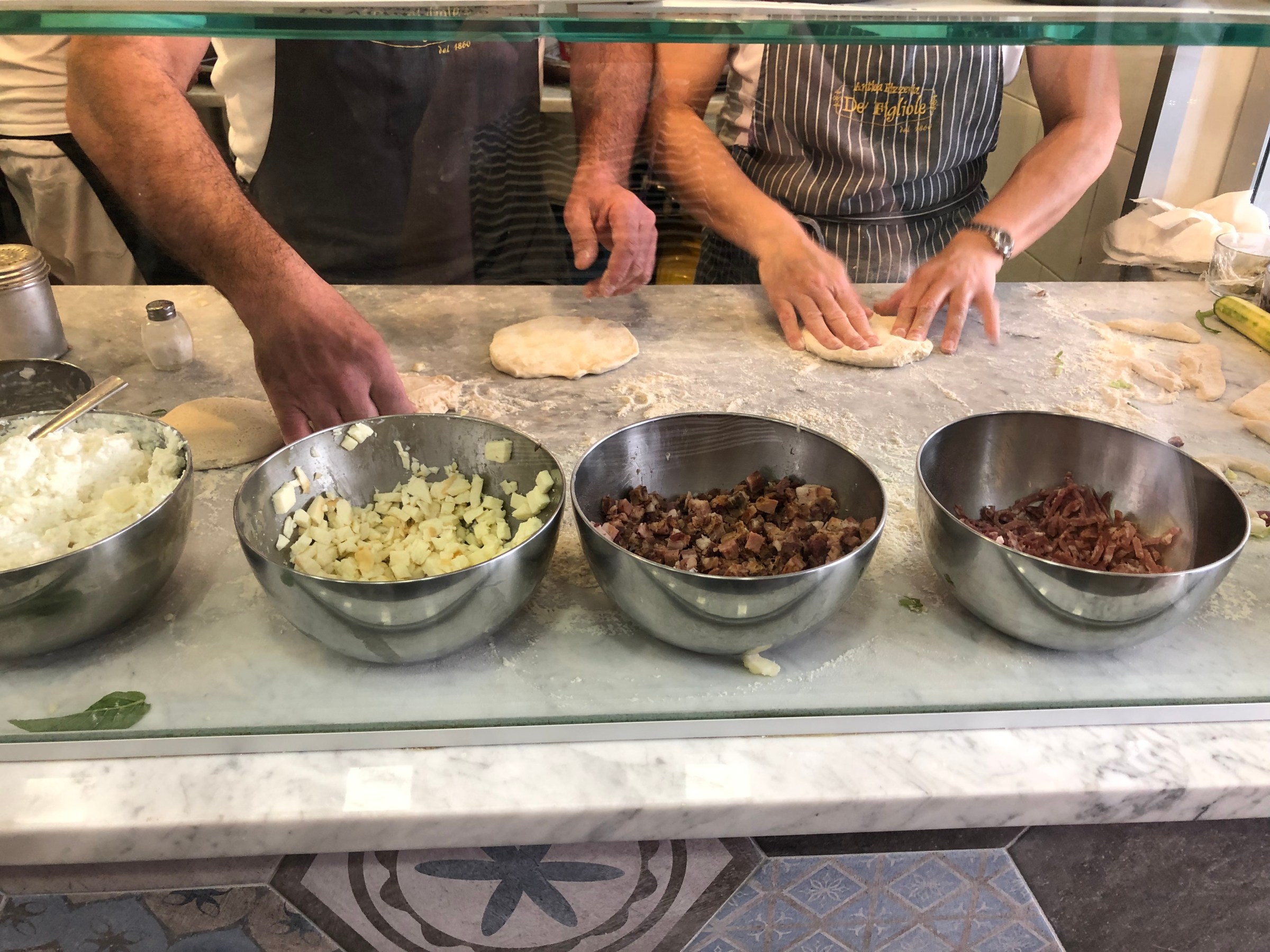 a group of people preparing food in a bowl