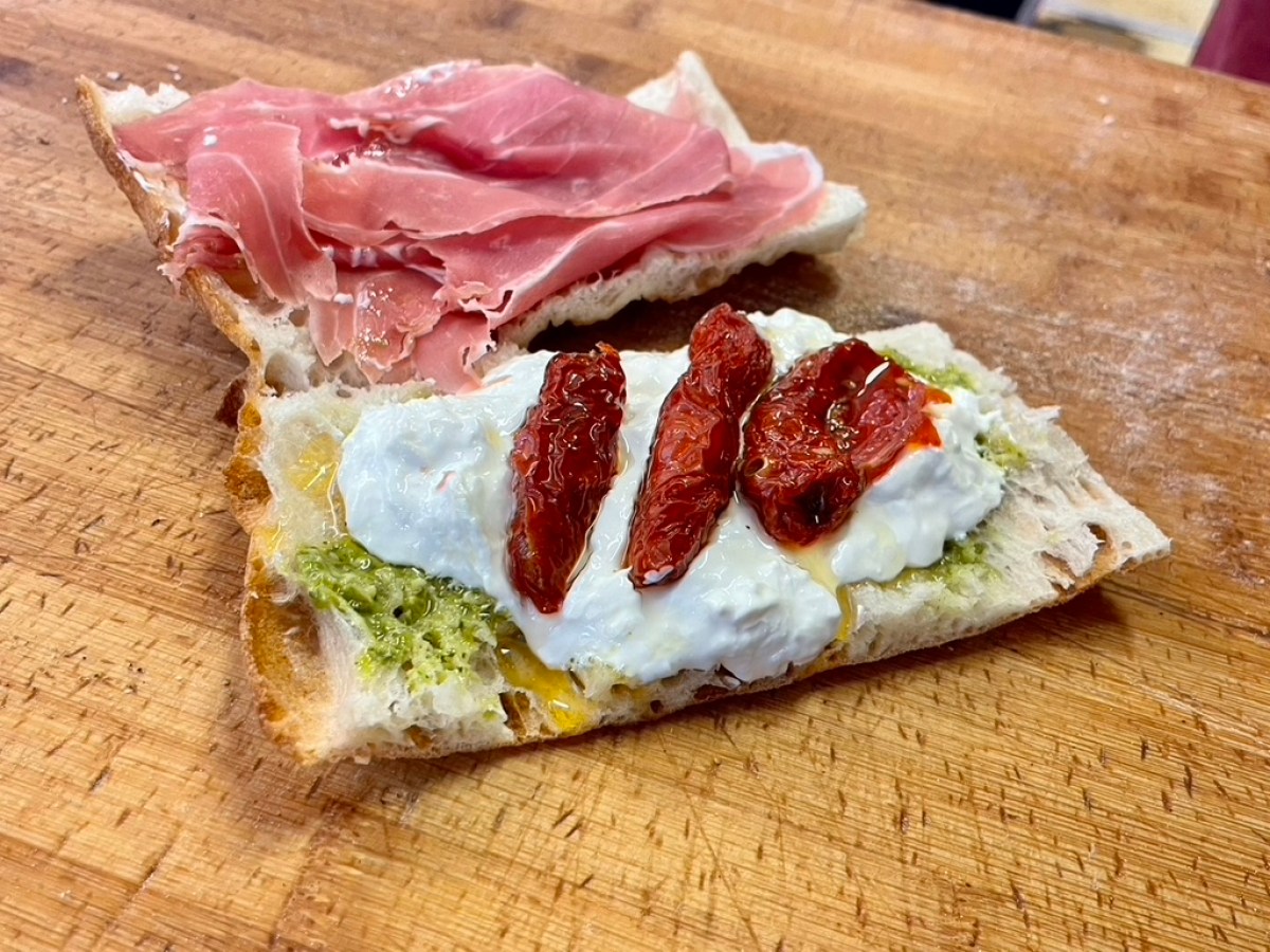 a cut in half sandwich sitting on top of a wooden cutting board