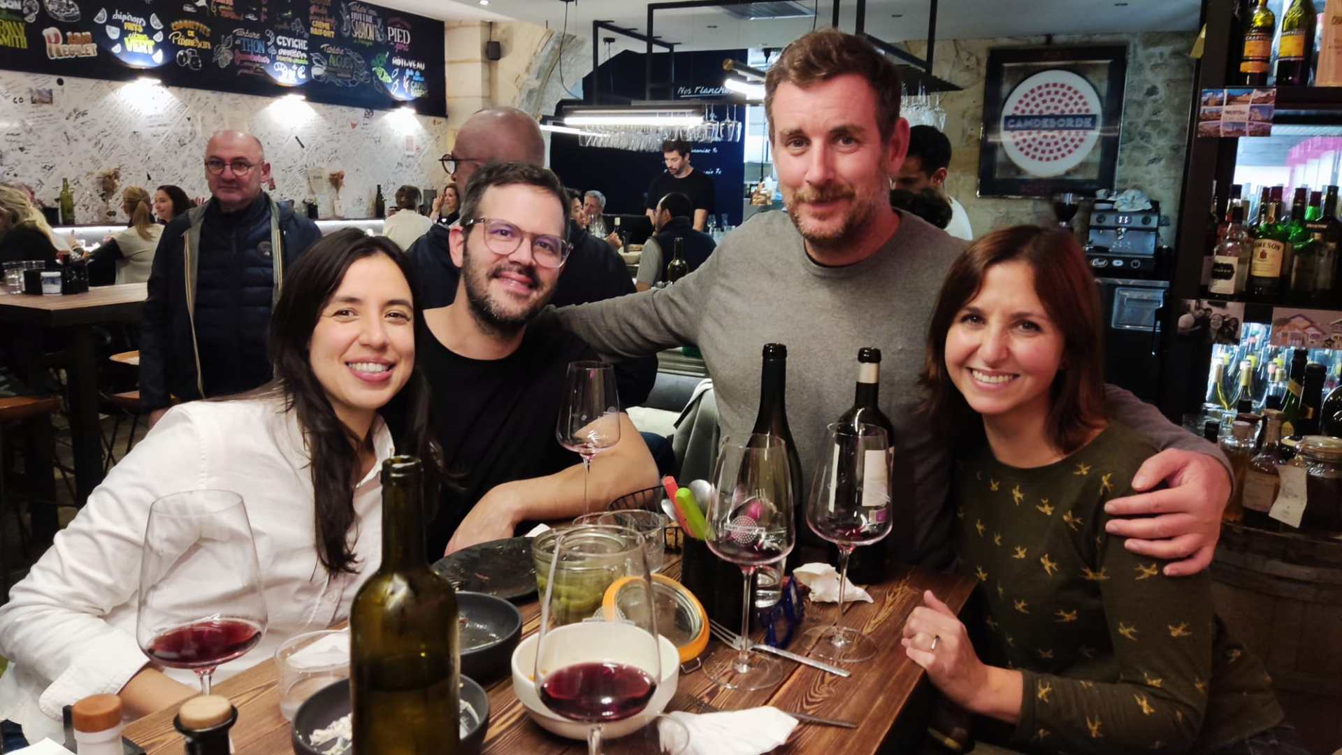Birol Güven et al. sitting at a table with wine glasses