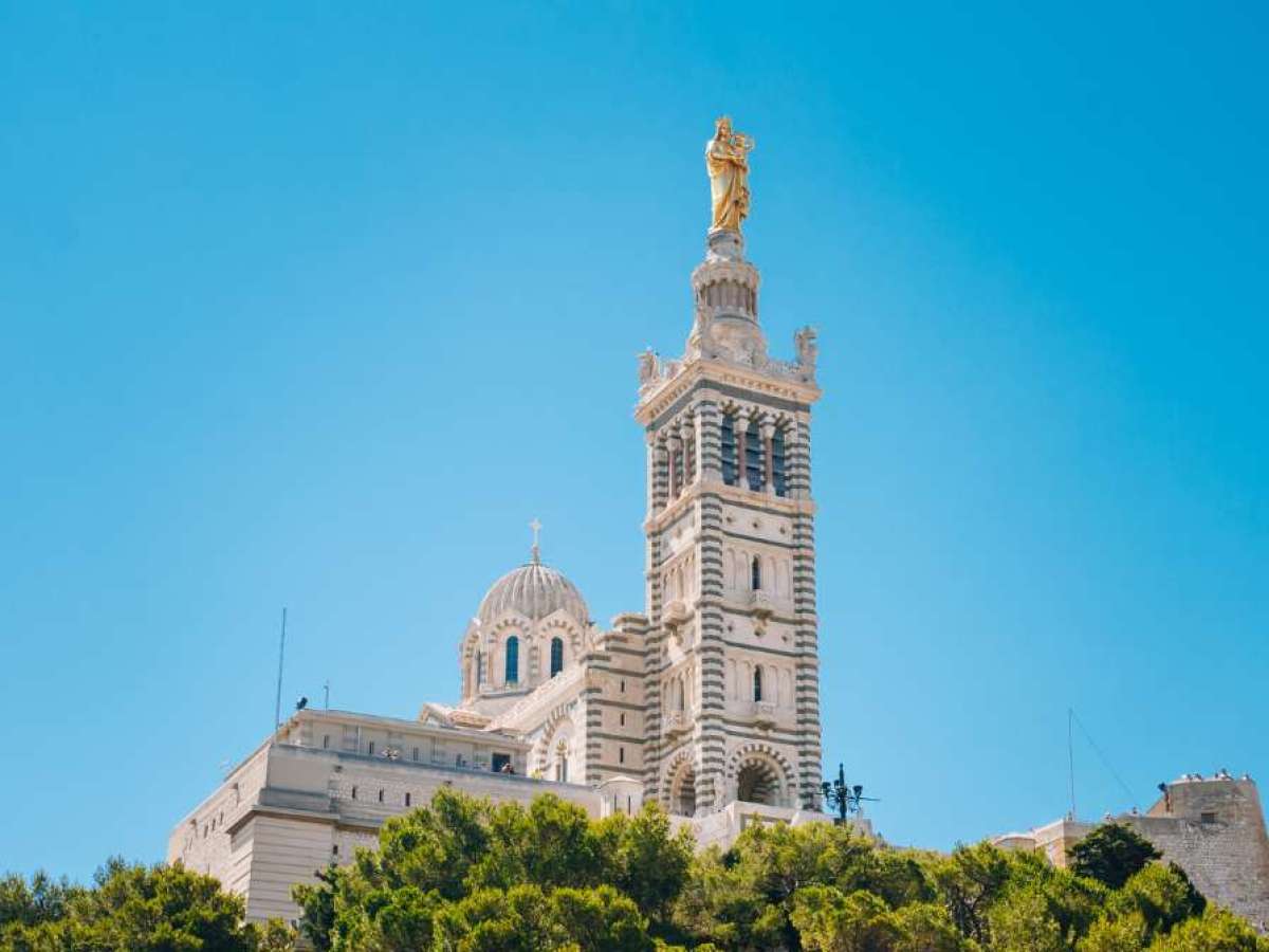 a large tall tower with a clock at the top of Notre-Dame de la Garde