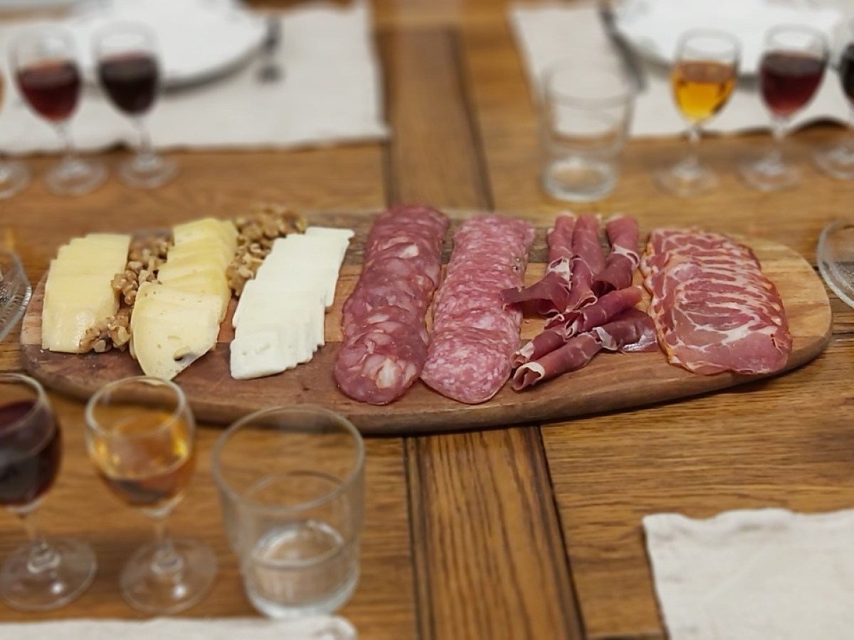 a cake sitting on top of a wooden table topped with glasses of wine