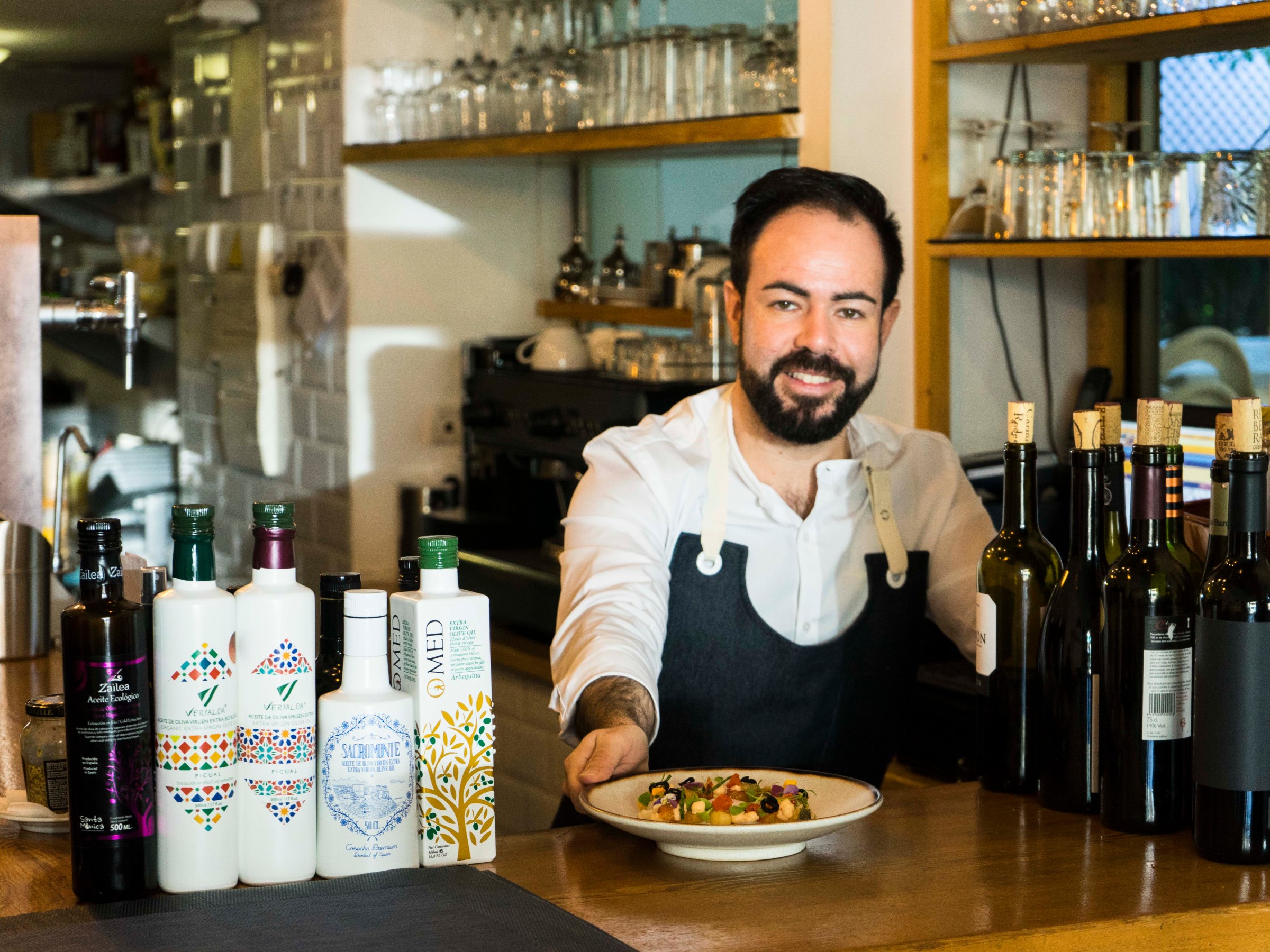 a person holding a bottle of wine on a table