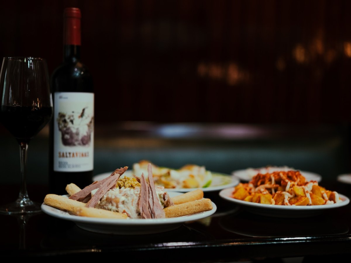 a plate of food and a bottle of wine on a table