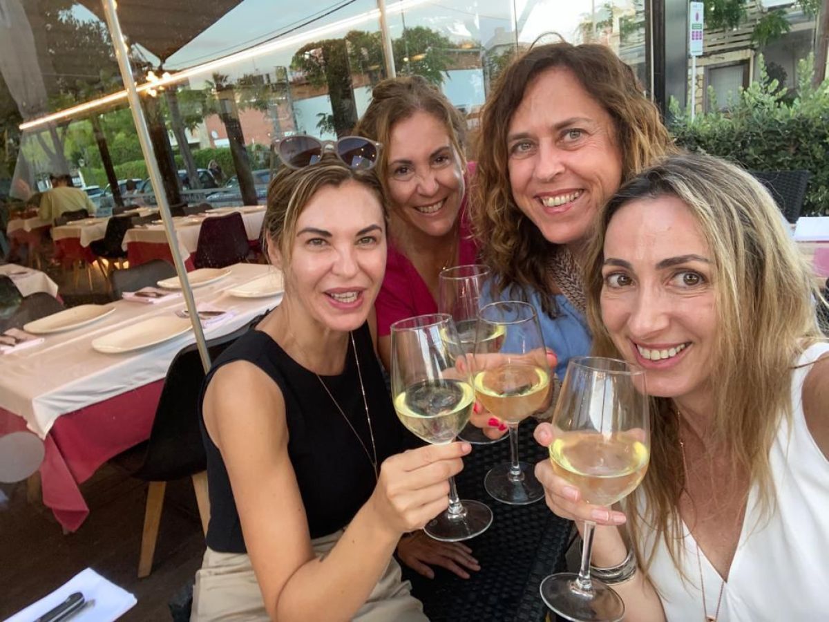 a group of people sitting at a table with wine glasses