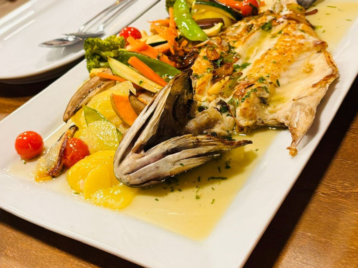 a person sitting at a table with a plate of food