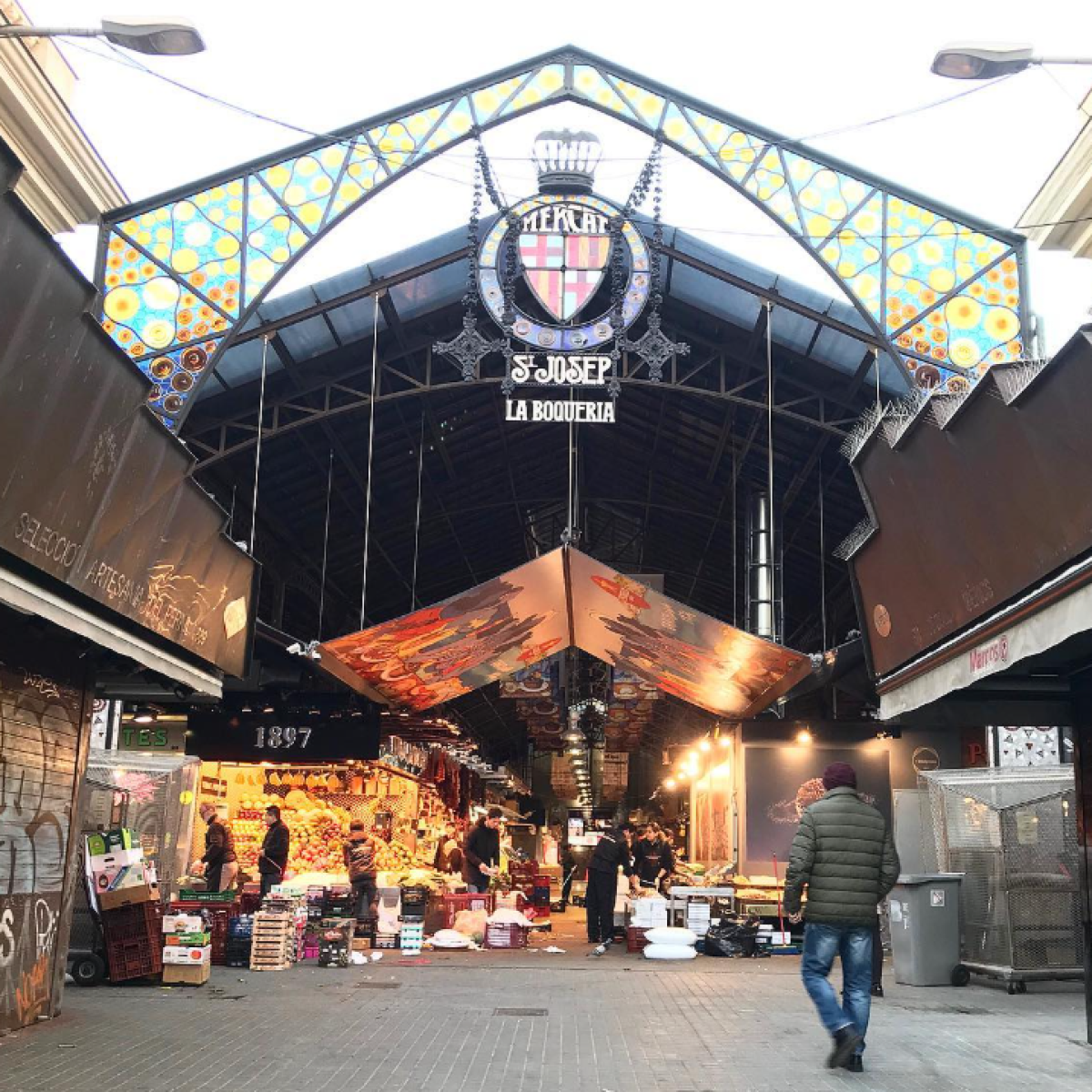 a group of people walking down a street next to a train station