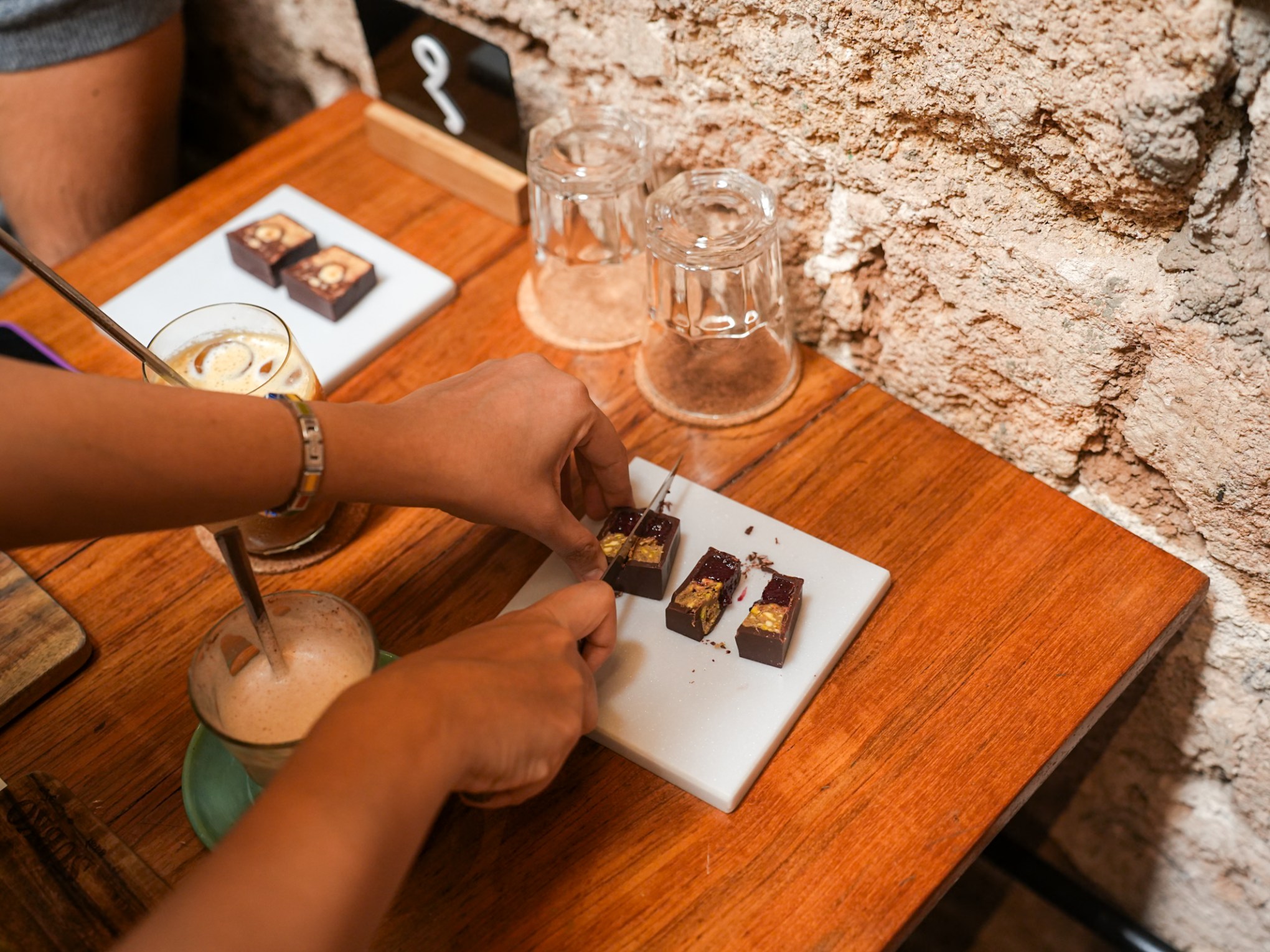 a person sitting at a table with wine glasses
