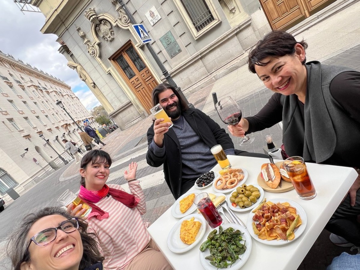 a group of people sitting at a table in front of a building