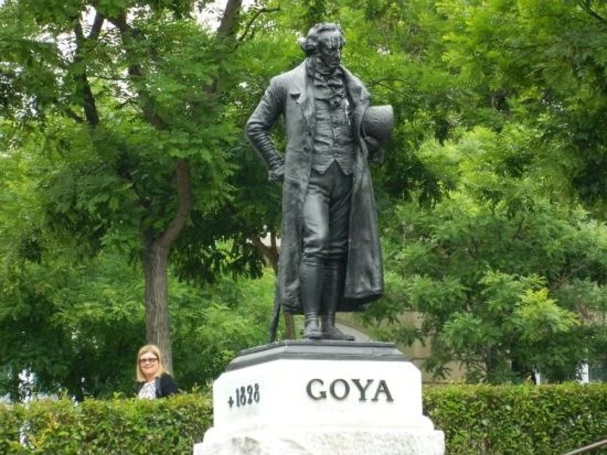 a statue of a man standing in front of a tree