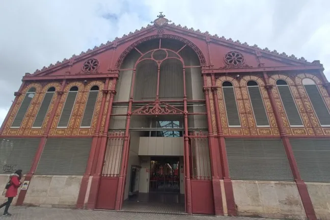 Ornate red-and-gold building facade with arched entrance and windows.