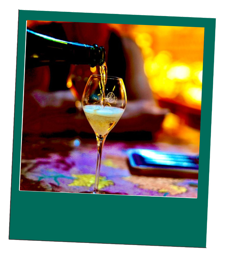 A glass of champagne being poured from a bottle on a colorful tablecloth.