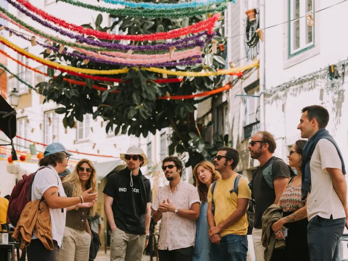 Group of people with a guide in a colorful, decorated street.