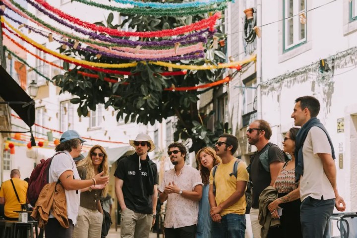Group of people with a guide in a colorful, decorated street.